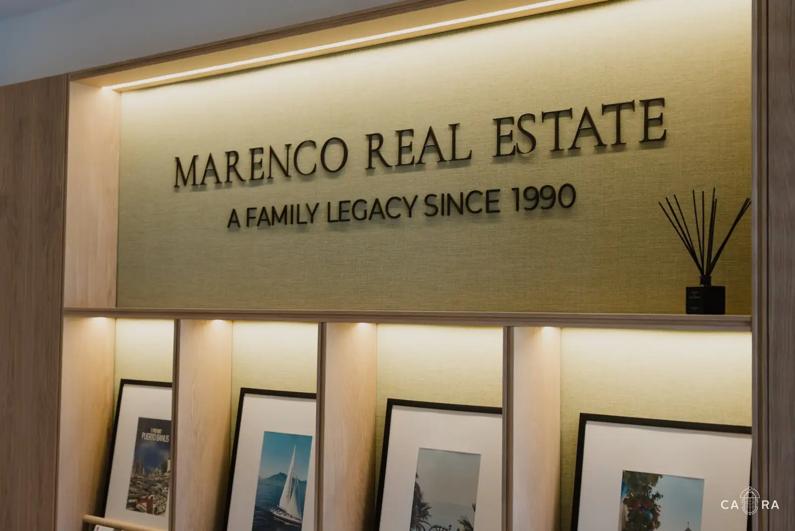 Marenco Real Estate lettering above lit oak display shelves