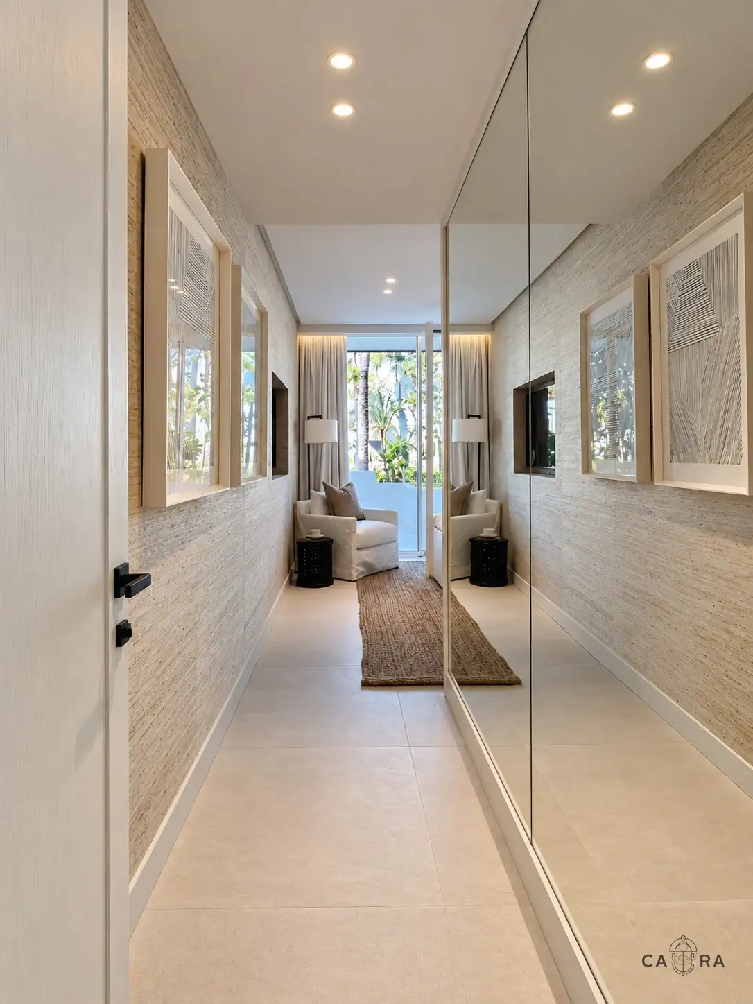 Grasscloth corridor with a mirrored wall leading to a reading chair by the garden window