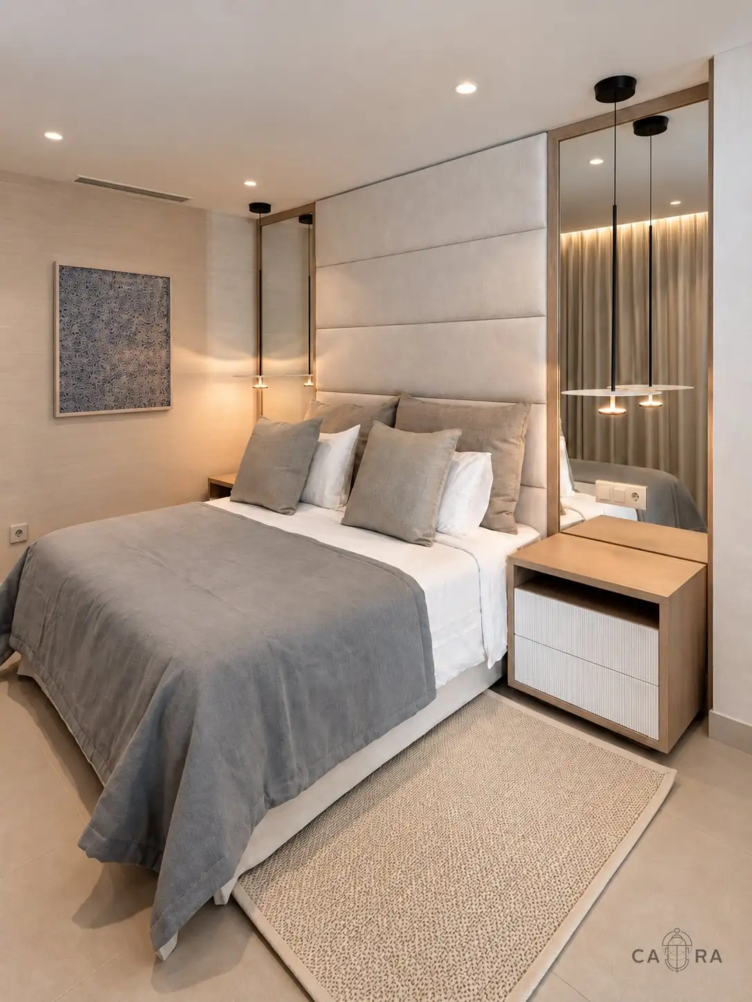 Bedroom with tall upholstered headboard and oak-framed mirrors