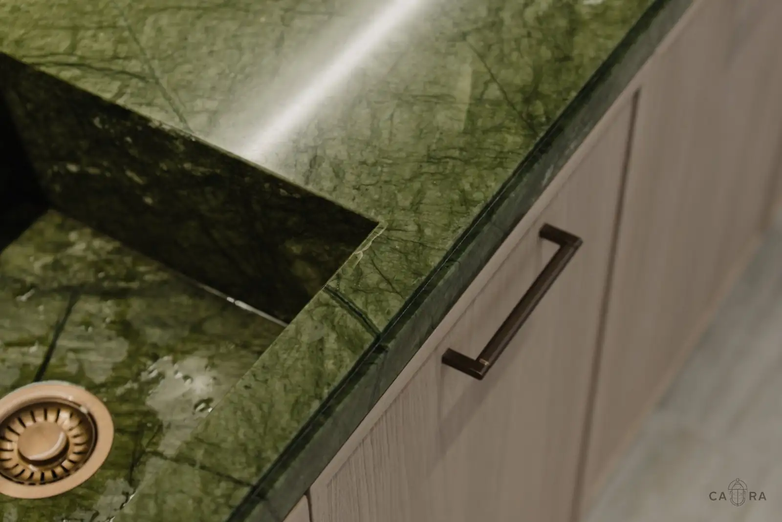 Green marble worktop and sink with bronze handle