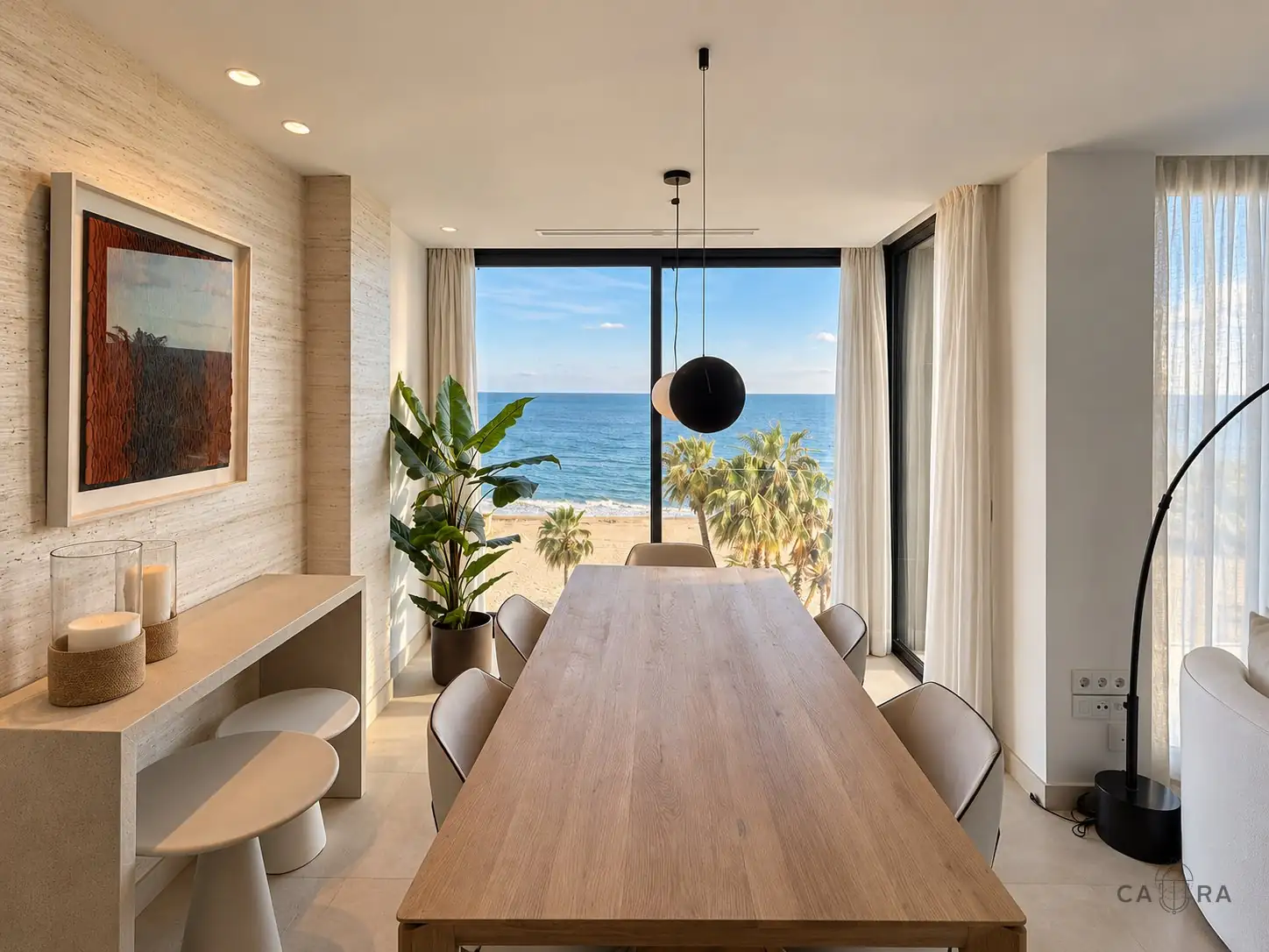 Dining table in oak facing a full-height window onto the beach