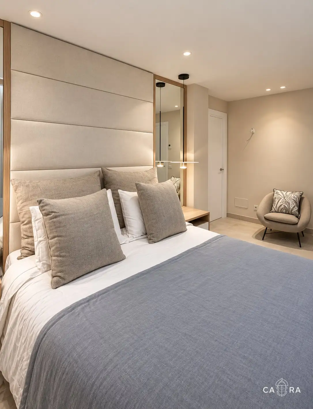 Bedroom with headboard, mirror and armchair